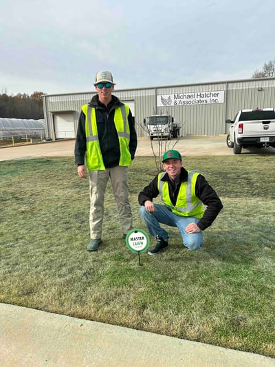 Two Master Lawn employees install a Master Lawn yard sign at the Michael Hatcher & Associates office in Huntsville, AL