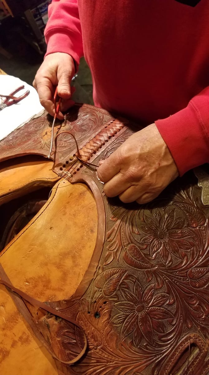 Tommy Neergaard stitching a leather saddle